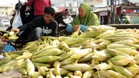 Seorang pedagang jagung melayani pembeli di Jalan Raya Bogor, Bogor, Kamis (31/12/2015). Jelang malam pergantian tahun 2016, sejumlah pedagang jagung musiman menggelar dagangannya di sepanjang Jalan Raya Bogor. (Liputan6.com/Helmi Fithriansyah)