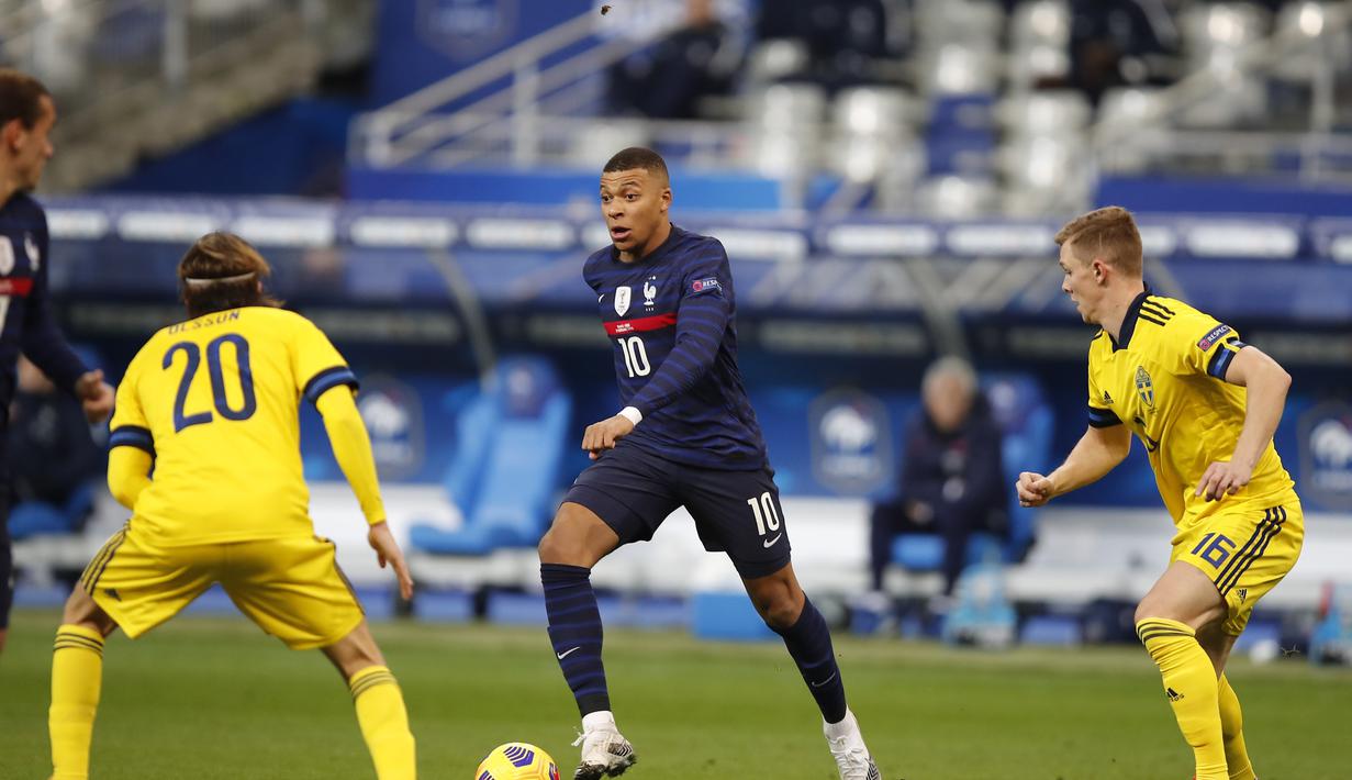 Penyerang Prancis, Kylian Mbappe membawa bola dari kawalan dua pemain Swedia, Emil Krafth dan Kristoffer Olsson pada pertandingan UEFA Nations League di stadion Stade de France di Saint-Denis, Paris (17/11/2020). Prancis menang atas Swedia 4-2. (AP Photo/Francois Mori)