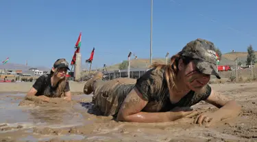 Perwira wanita Peshmerga melakukan latihan saat mengambil bagian dalam upacara kelulusan di Kota Soran, Irak, Rabu (16/10/2019). Latihan pasukan bersenjata Kurdi tersebut dilakukan sekitar 100 kilometer timur laut ibu kota otonomi wilayah Kurdi di Irak, Arbil. (SAFIN HAMED/AFP)