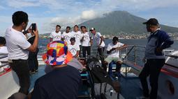 Sejumlah pemain dan staf Malut United berfoto bersama di atas kapal ferry dengan latar belakang gunung ketika menuju Tidore, Maluku Utara. (Bola.com/Okie Prabhowo)