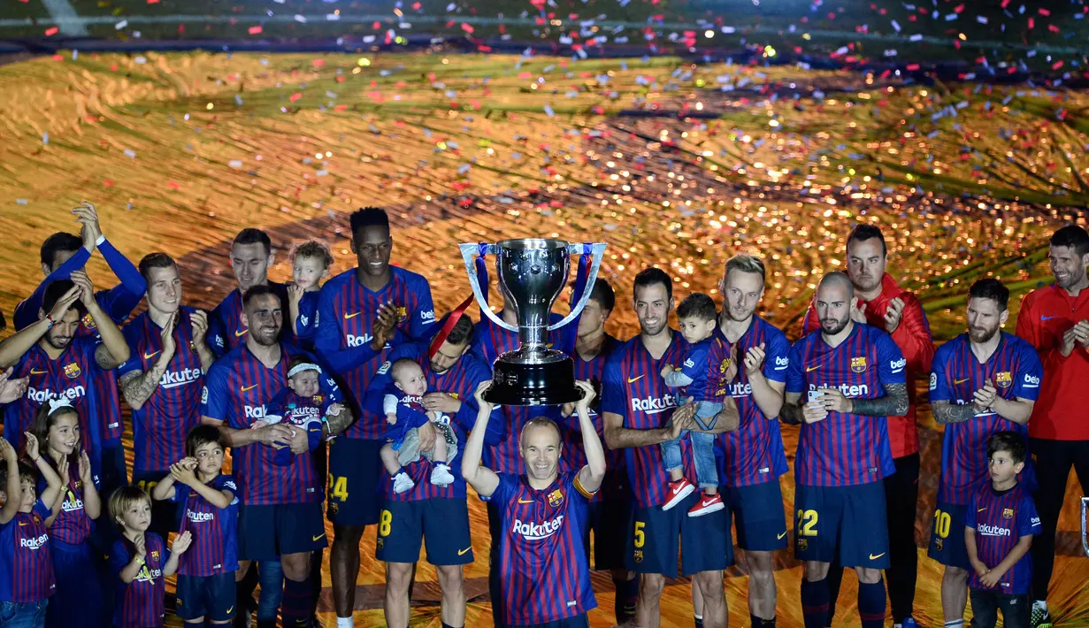 Gelandang Barcelona, Andres Iniesta mengangkat trofi Liga pada momen perpisahan usai laga penutup La Liga Spanyol melawan Real Sociedad di Camp Nou, Minggu (20/5). Iniesta resmi meninggalkan Barcelona setelah 22 tahun berkarier di sana (AFP/LLUIS GENE)