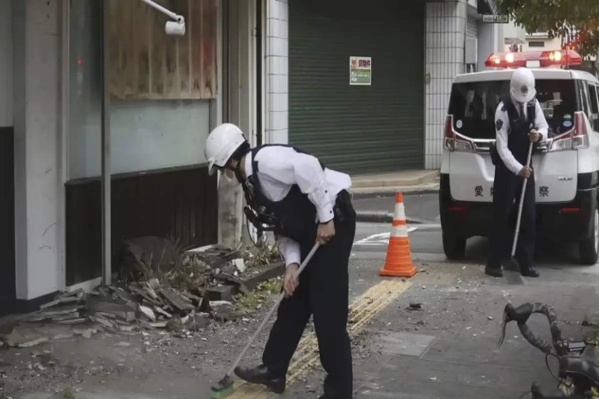 Petugas polisi membersihkan puing-puing gempa di Uwajima, prefektur Ehime, Jepang bagian barat Kamis, 18 April 2024. (Kyodo News/AP)