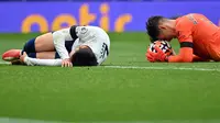 Winger Tottenham Hotspur Son Heung-min (kiri) kesakitan usai berbenturan dengan kiper Chelsea Kepa Arrizabalaga pada laga Liga Inggris, Minggu (19/9/2021). (AFP/Justin Tallis)
