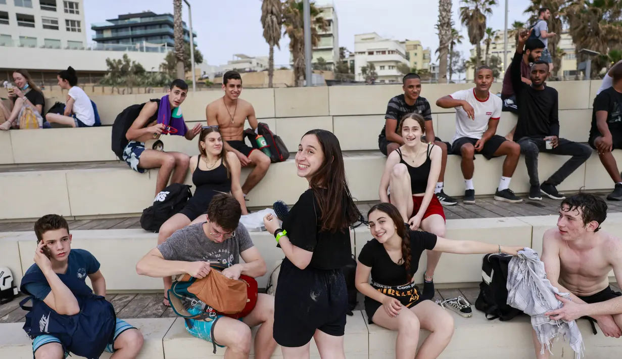 Pemuda berkumpul di kota pesisir Israel Tel Aviv (19/4/2021). Jumlah kasus virus corona di Israel turun dari sekitar 10.000 infeksi baru per hari pada pertengahan Januari menjadi sekitar 200 kasus per hari. (AFP/menahem kahana)