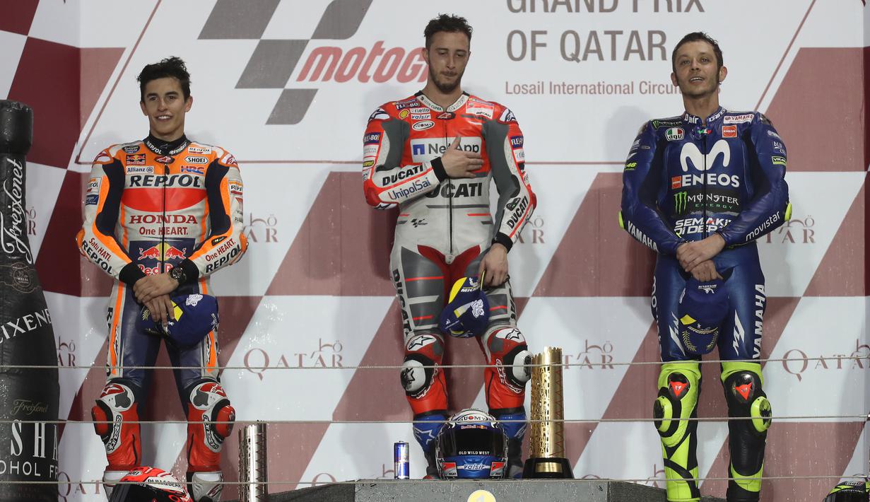 Pembalap Ducati Andrea Dovizioso yang meraih juara satu (tengah) bersama Marc Marquez (kiri) dan Valentino Rossi berada di podium usai mengikuti balapan di MotoGP Qatar 2018 di Sirkuit Internasional Losail (18/3). (AFP Photo/Karim Jaafar)