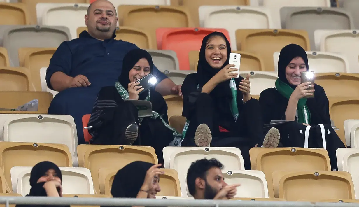 Suporter wanita klub Al-Ahli asal Arab Saudi antusias menyaksikan laga timnya melawan Al-Batin pada Saudi Pro League di King Abdullah Sports City, Jeddah, (12/1/2018). Arab Saudi untuk pertama kalinya mengizinkan wanita menonton di stadion. (AFP/STRINGER)