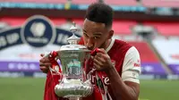 Striker Arsenal, Pierre-Emerick Aubameyang mencium trofi saat merayakan gelar juara Piala FA setelah mengalahkan Chelsea pada pertandingan final Piala FA di stadion Wembley, Minggu (2/8/2020).  Aubameyang menjatuhkan trofi saat prosesi selebrasi. (Adam Davy/Pool via AP)