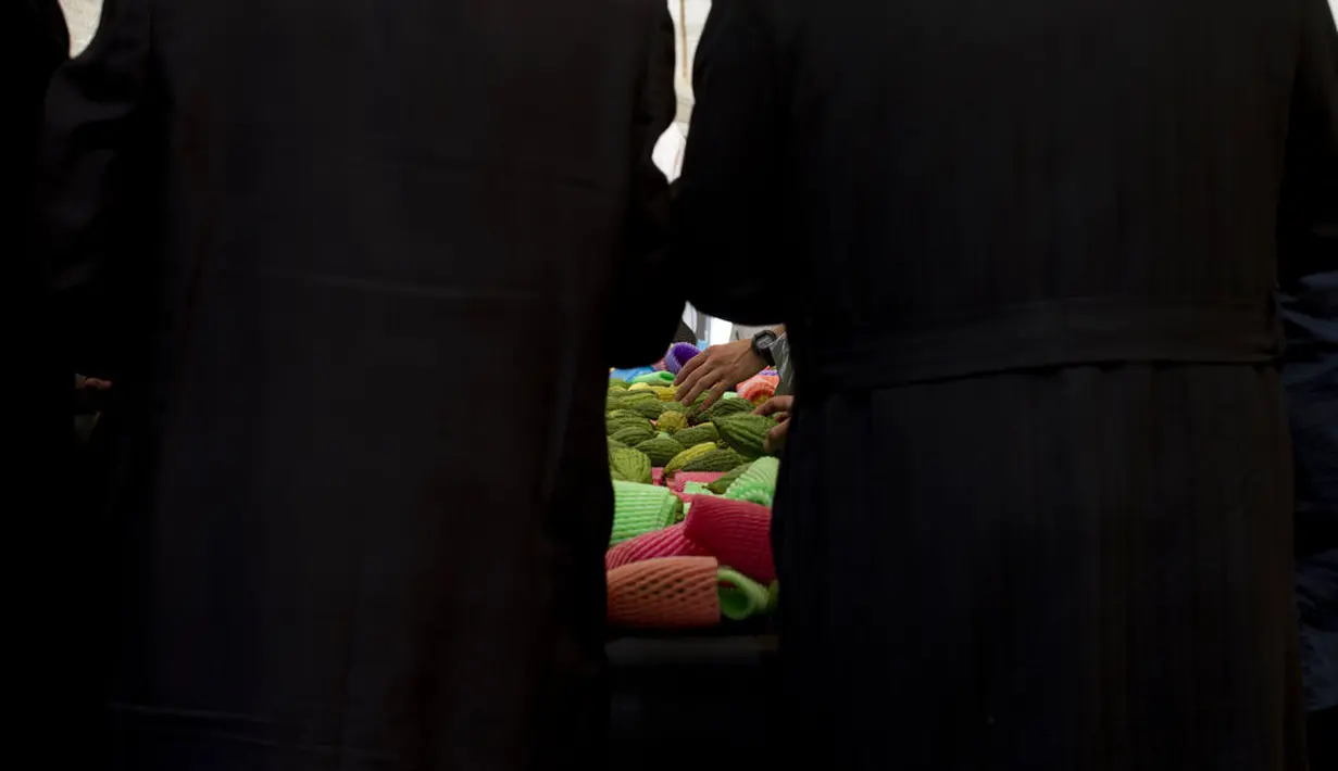 Warga Yahudi ultra-Ortodoks memeriksa buah jeruk etrog di Yerusalem, Senin (20/9/2021). Jeruk Etrog digunakan warga Yahudi dalam ritual Sukkot atau Hari Raya Pondok Daun yang disebut juga dengan perayaan Tabernakel. (AP Photo/Maya Alleruzzo)