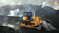Sebuah bulldozer sedang bekerja di antara timbunan batubara yang asapnya mengepul (Liputan6.com/ Panji Diksana)