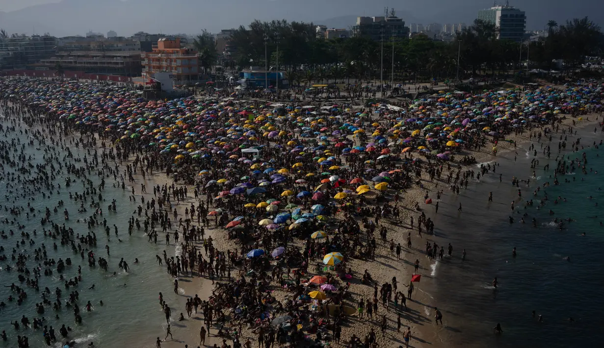 Para penjemur menikmati pantai Macumba, di zona barat Rio de Janeiro, pada 24 September 2023. (Tercio Teixeira/AFP)