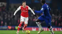 Gelandang Arsenal, Mesut Ozil, menggiring bola saat menghadapi Chelsea pada laga Premier League pekan ke-24 di Stamford Bridge, London, Rabu (22/1). Arsenal tahan imbang Chelsea 2-2. (AFP/Ben Stansall)