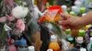 Seorang wanita manaruh bunga untuk untuk korban Penikaman Massal di Kawasaki, Jepang (29/5/2019). Kepolisian Jepang mengonfirmasi bahwa penikaman massal di kota tersebut menewaskan seorang anak perempuan berusia 11 tahun yang duduk di bangku SD dan pria berusia 39 tahun. (Reuters/Issei Kato)