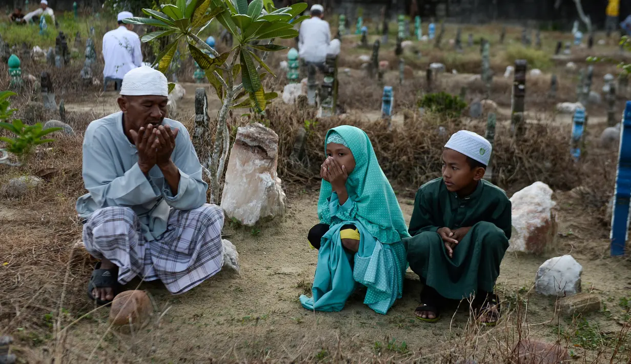 Muslim Thailand berdoa saat menziarahi kuburan kerabat mereka pada perayaan Idul Adha di provinsi Narathiwat, Minggu (11/8/2019). Pada setiap Idul Adha atau menyambut hari besar Islam sebagian warga banyak mendatangi kuburan untuk mendoakan keluarganya. (Madaree TOHLALA/AFP)