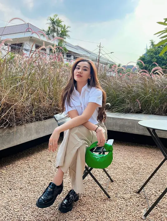 Seperti potret ini, Aaliyah tampil kece memadukan sepatu loafers seharga Rp18 jutaan-nya dengan kemeja putih, loose pants warna beige, dan handbag warna hijau sebagai statement. [Foto: IG/@aaliyah.massaid/@fuji_an]