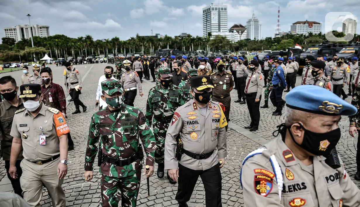 Kapolda Metro Jaya Irjen Pol Muhammad Fadil Imran didampingi Pangdam Jaya Mayjen TNI Dudung Abdurachman dan Wakil Gubernur Riza Patria meninjau barisan pasukan saat apel Operasi Lilin Jaya 2020 di Lapangan Silang Monas, Jakarta, Senin (21/12/2020). (merdeka.com/Iqbal S. Nugroho)
