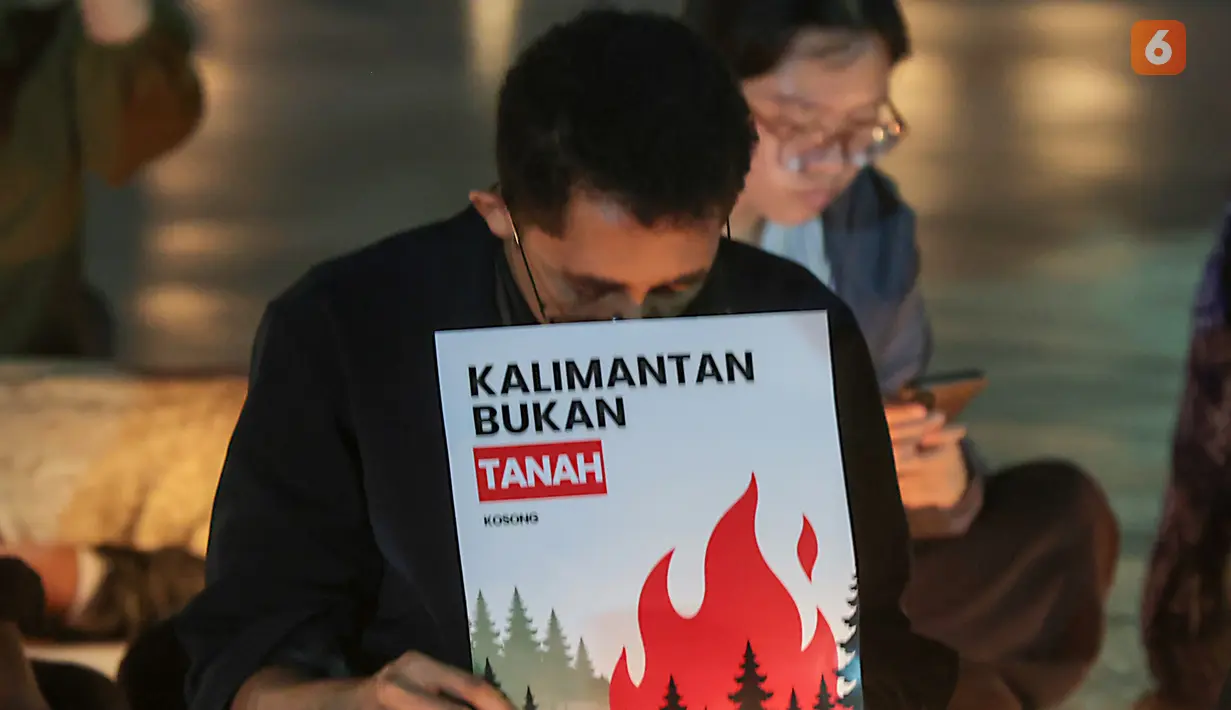 Sejumlah poster yang dibawa simpatisan masyarakat turut mewarnai aksi solidaritas dan doa bersama untuk korban kebakaran hutan dan lahan (karhutla) di Tugu Proklamasi, Jakarta, Senin malam (19/10/2026). (KLY/Budy Santoso)