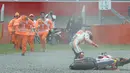 Marc Marquez berusaha mendirikan kembali motornya usai terpental dari lintasan saat berlaga di Grand Prix Argentina, Minggu (9/4). Marc Marquez hilang kendali saat hendak menikung ke kiri. (AP Photo/ Natacha Pisarenko)