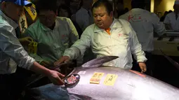 CEO Sushi Zanmai, Kiyoshi Kimura memeriksa ikan tuna seharga 74,2 juta yen (setara Rp 85 miliar) di depan restorannya, dekat pasar ikan Tsukiji, Tokyo, Kamis (5/1). Kimura memenangkan ikan itu pada lelang tuna pertama tahun 2017. (TOSHIFUMI KITAMURA/AFP)