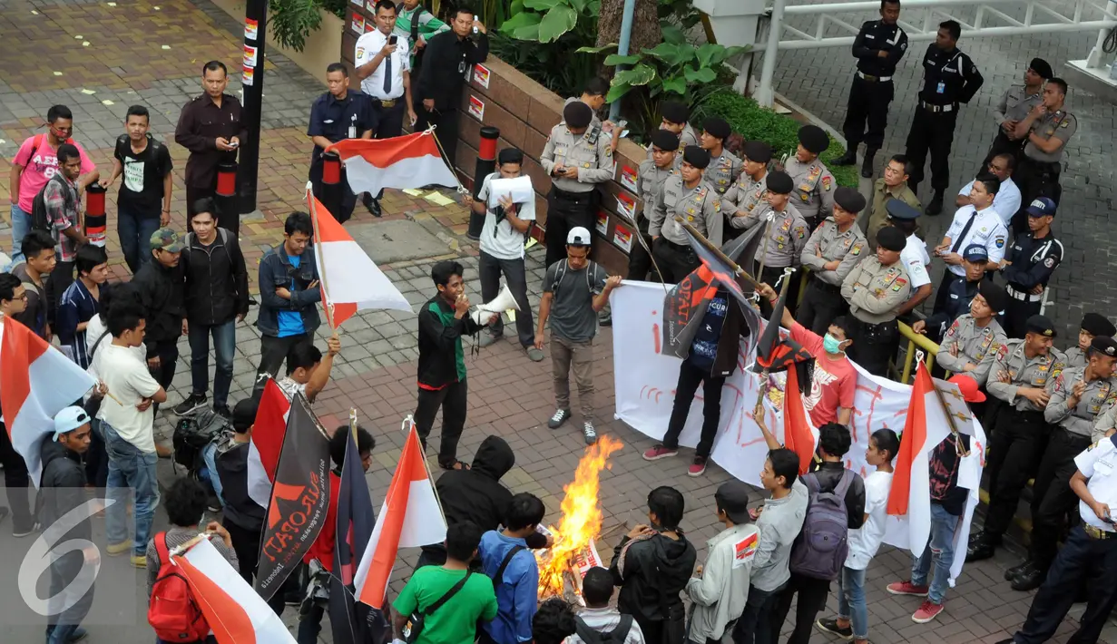 Petugas polisi berjaga di depan kantor Freeport, Kuningan , Jakarta, Jumat (18/12). Dalam aksinya mereka menuntut pemerintah untuk segera melakukan nasionalisasi terhadap PT Freeport. (Liputan6.com/Helmi Afandi)