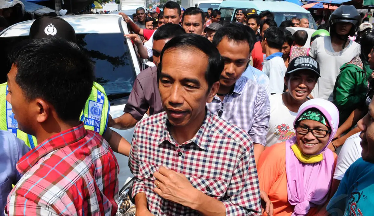 Warga dan pedagang pasar Kebayoran Lama tampak mengerumuni laki-laki yang akrab disapa Jokowi itu, Jakarta, Senin (30/6/14). (Liputan6.com/Andrian M Tunay)