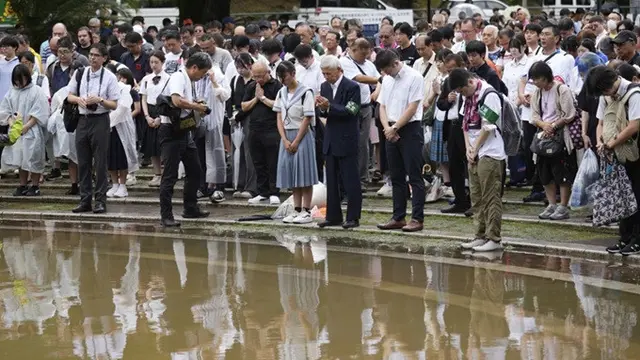 Orang-orang mengheningkan cipta selama satu menit di Taman Hiposentrum Bom Atom, Nagasaki, Jepang, saat upacara peringatan 80 tahun bom atom Nagasaki, pada Sabtu, (9/8/2025).