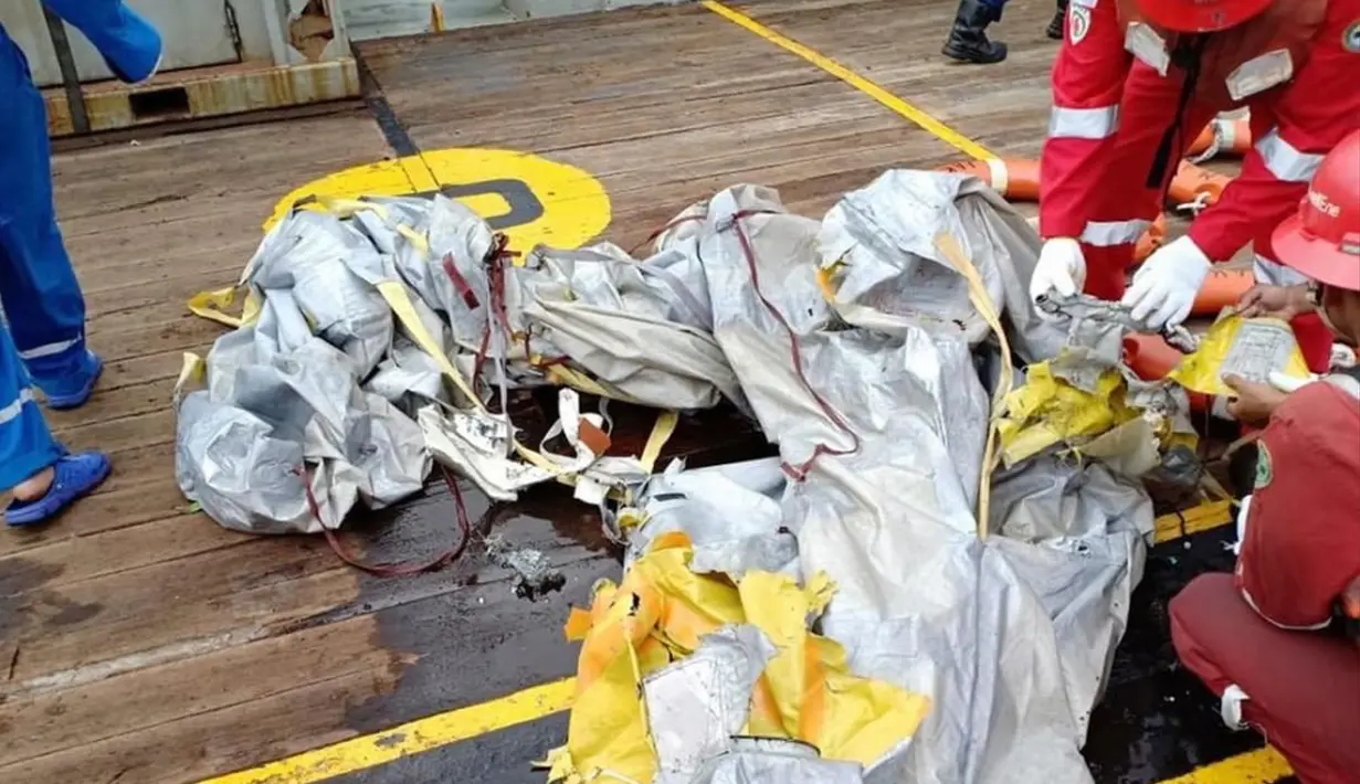 Petugas memeriksa puing dari pesawat Lion Air bernomor penerbangan JT-610 rute Jakarta-Pangkalpinang yang jatuh di perairan Tanjung Karawang, Jawa Barat, Senin (29/10). (HO/NATIONAL DISASTER MITIGATION AGENCY/PERTAMINA HULU ENERGY / AFP)