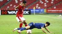 Pemain Indonesia Pratama Arhan Alif Rifai memperebutkan bola dengan pemain Thailand Supachok Sarachat pada pertandingan sepak bola leg kedua final Piala AFF 2020 di National Stadium, Singapura, Sabtu (1/1/2022). Pertandingan berakhir dengan skor 2-2. (AP Photo/Suhaimi Abdullah)