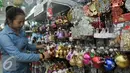 Karyawan toko merapikan barang dagangannya di kawasan Pasar Baru, Jakarta, Kamis (15/12). Jelang perayaan Na¬tal 25 Desember 2016 mendatang, se¬jumlah toko pernak-pernik natal mulai ra¬mai dikunjungi pembeli.(Liputan6.com/Yoppy Renato)