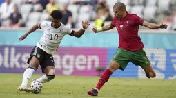 Penyerang Jerman, Serge Gnabry (kiri) berusaha melewati bek Portugal, Pepe pada pertandingan grup F Euro 2020  di Allianz Arena, Munich, Sabtu (19/6/2021). Jerman untuk sementara duduk di posisi kedua dengan poin sama seperti Portugal. (AP Photo/Matthias Schrader, Pool)