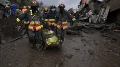 Petugas membawa jenazah korban banjir bandang yang dipicu oleh hujan yang memenuhi aliran sungai terdekat yang merusak mekanisme penahanan dan meruntuhkan lereng bukit dan membawa gelombang lumpur ke rumah-rumah di daerah La Gasca di Quito, Ekuador, Selasa (1/2/2022). (AP Photo/Dolores Ochoa)