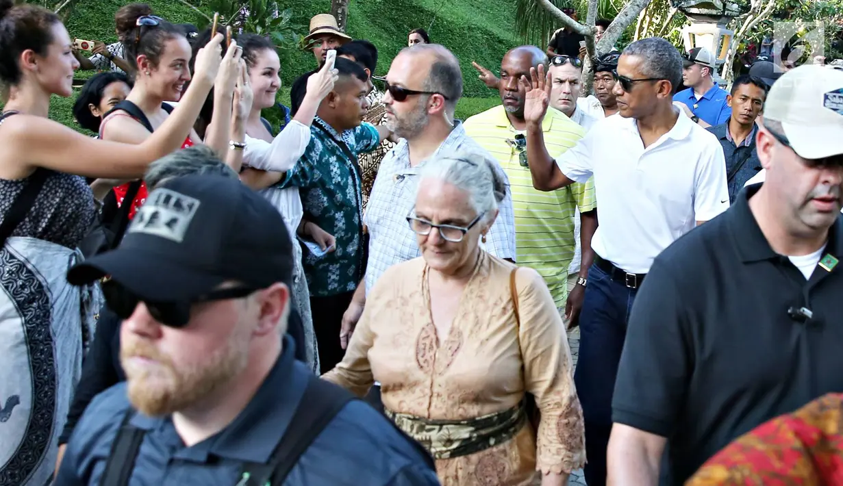 Mantan Presiden AS, Barack Obama menyapa turis saat berkunjung ke Pura Tirta Empul, Tampaksiring, Gianyar, Bali, Selasa (27/6). Kunjungan Obama tersebut mendapat sambutan antusias dari pengunjung yang memadati pura. (Liputan6.com/Immanuel Antonius)
