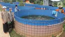 Santri melihat ikan mujair nila merah di budidaya ikan Pesantren Ruhama Al Fajar, Citayam, Bogor, Jawa Barat, Selasa (29/6/2021). Di Masa pandemi Covid-19 peran pemulihan ekonomi nasional kini menyasar ke pesantren dalam pemulihan ketahanan pangan. (merdeka.com/Arie Basuki)