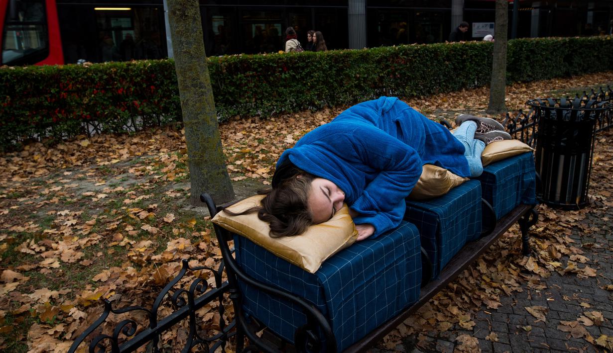 Aktivis berbaring di bangku di pusat kota Bratislava, 8 November 2018. Aksi itu untuk menunjukkan solidaritas kepada tunawisma di Hungaria yang dilarang tidur di tempat-tempat umum setelah diberlakukannya undang-undang tunawisma. (VLADIMIR SIMICEK/AFP)