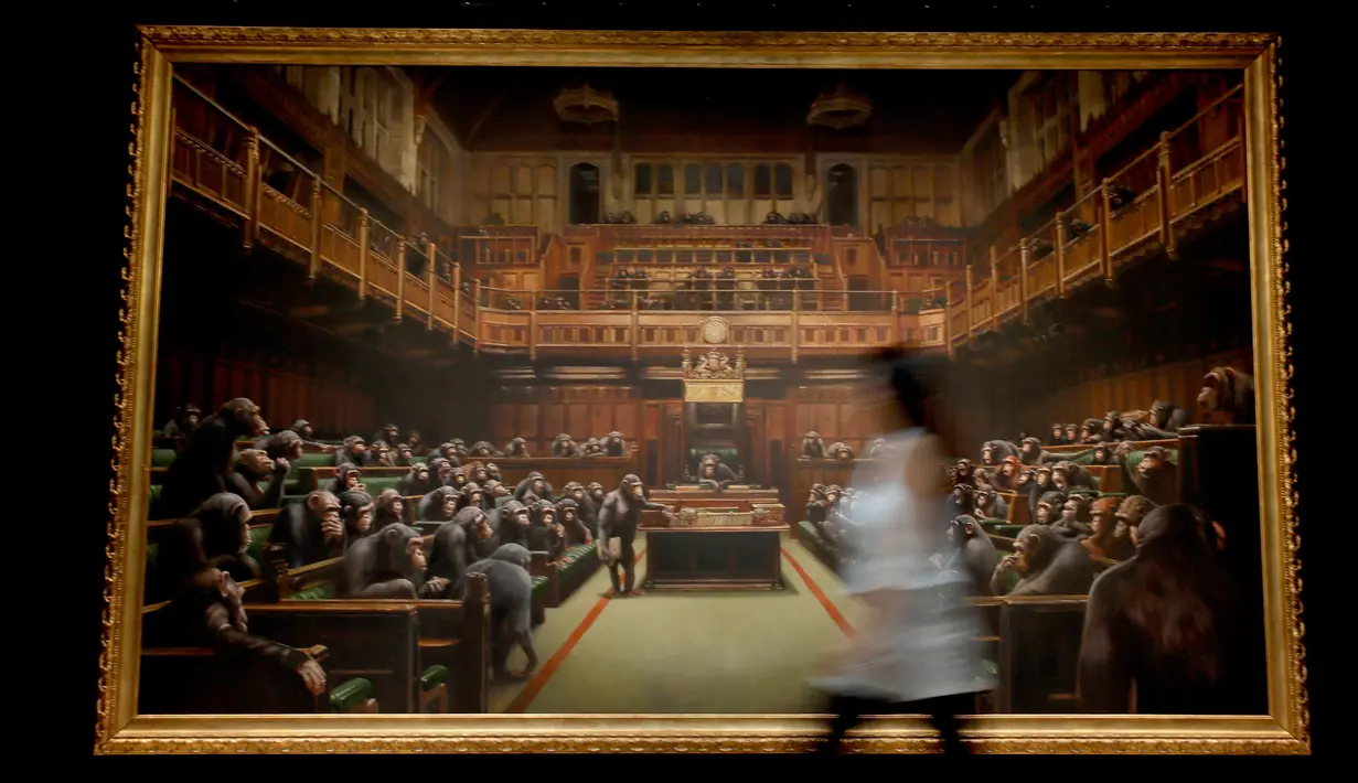 Petugas melintas di depan lukisan seniman jalanan Banksy yang dipajang di ruang lelang Sotheby, London, Jumat (27/9/2019). Lukisan tersebut pernah dipajang di pameran 'Banksy vs Bristol Museum' pada 2009 dan menarik lebih dari 300 ribu pengunjung. (AP/Kirsty Wigglesworth)