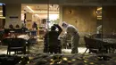 Seorang tamu mengenakan maskernya saat seorang pramusaji yang mengenakan pakaian pelindung diri atau hazmat menyerahkan tanda terima kepadanya di sebuah restoran di dalam Hotel Shangri-La pada Olimpiade Musim Dingin 2022, 16 Februari 2022, di Beijing. (AP Photo/Jae C.Hong)