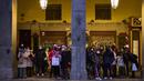 Orang-orang yang memakai masker untuk melindungi diri dari penyebaran virus corona, menunggu hujan berhenti di pusat kota Madrid, Spanyol (8/12/2021). PM Spanyol mendesak warga untuk "tetap berhati-hati" tentang COVID-19 selama liburan perayaan Natal. (AP Photo/Manu Fernandez)
