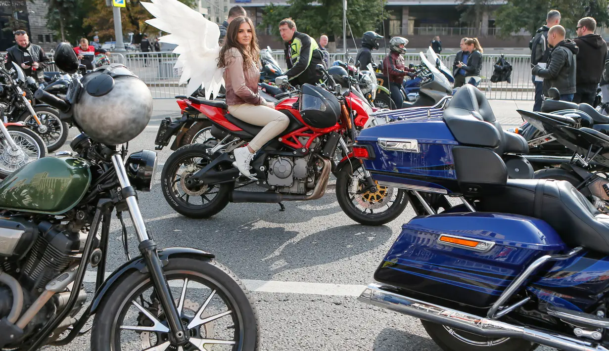 Seorang gadis yang mengenakan aksesori sayap duduk di atas sepeda motor jelang parade sepeda motor yang menandai penutupan musim sepeda motor di Moskow, Rusia, pada 26 September 2020. Beberapa ribu pengendara sepeda motor ikut serta dalam parade tersebut. (Xinhua/Alexander Zemlianichenko Jr)