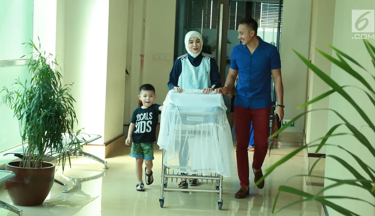 Soraya Larasati dan suaminya Doni Amaldi dan putra pertamanya menuju ruang jumpa pers, Jakarta, Kamis (8/6). Soraya Larasati melahirkan anak keduanya senin (5/6/2017). (Liputan6.com/Herman Zakharia)