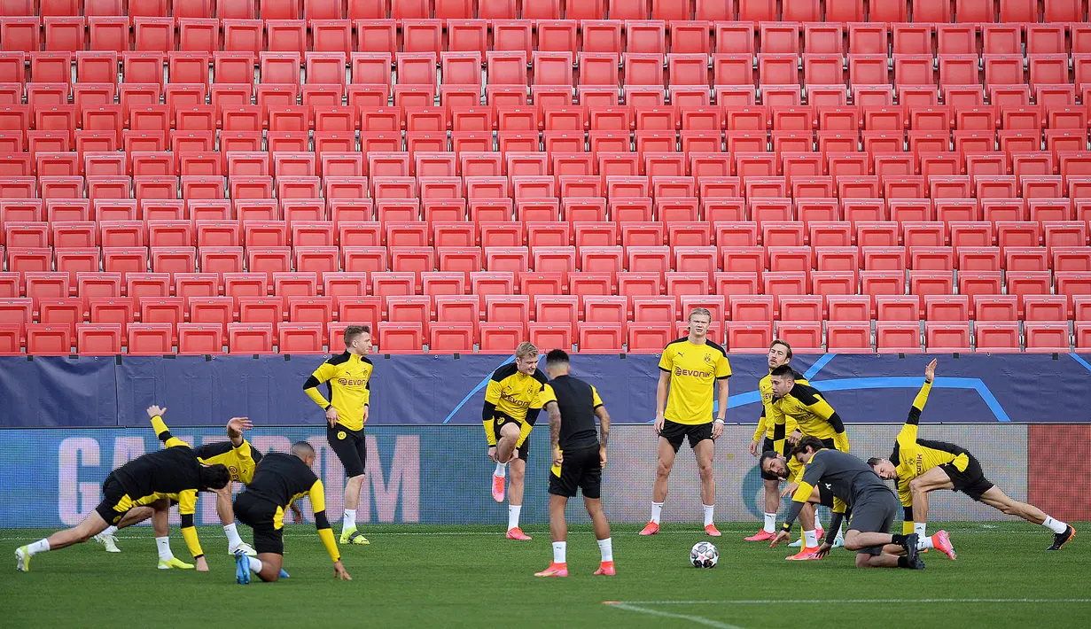 Para pemain Borussia Dortmund melakukan pemanasan saat mengikuti sesi latihan di stadion Ramon Sanchez Pizjuan di Seville (16/2/2021).  Die Borussen, julukan Dortmund, saat ini dalam performa kurang baik karena dalam dua laga terakhir belum memetik kemenangan. (AFP/Cristina Quicler)