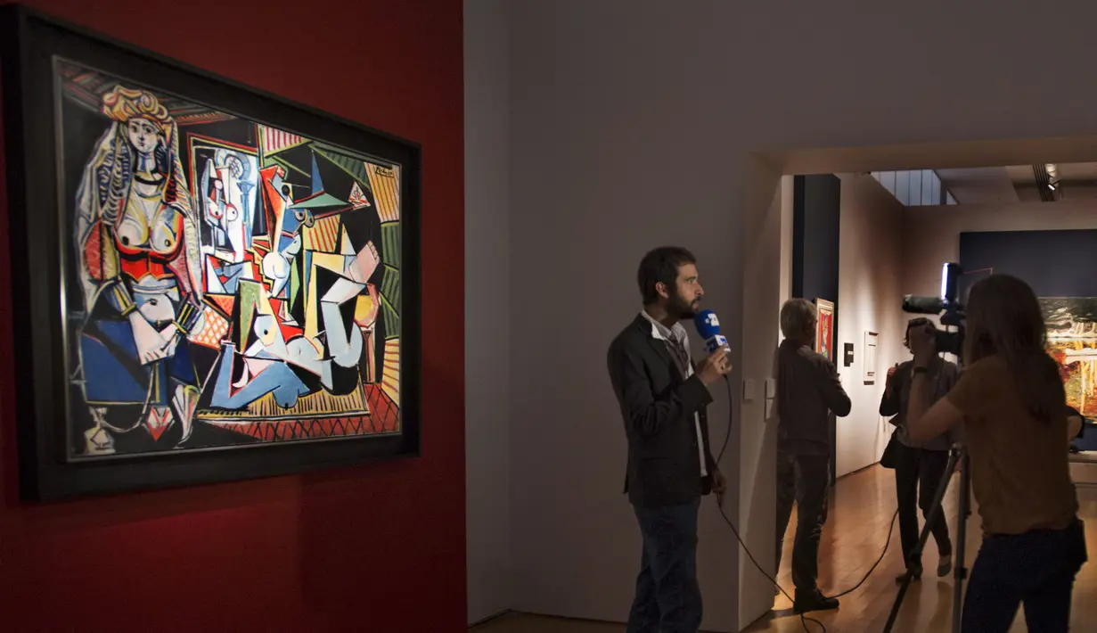Seorang awak media memberikan laporan di depan lukisan karya Pablo Picasso berjudul ‘Women of Algiers’ di Balai Lelang Christie, New York, Senin (11/5). Lukisan itu terjual seharga 179,3 juta dolar AS atau sekitar Rp 2,36 triliun. (REUTERS/Darren Ornitz)