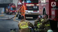 Petugas pemadam kebakaran beristirahat setelah melakukan pendingan di Gedung Kejaksaan Agung RI yang terbakar, Minggu (23/8/2020). Kebakaran di gedung Kejaksaan Agung pada Sabtu (22/8) malam akhirnya padam dan kini bangunan tersebut menyisakan bagian hitam legam. (Liputan6.com/Faizal Fanani)