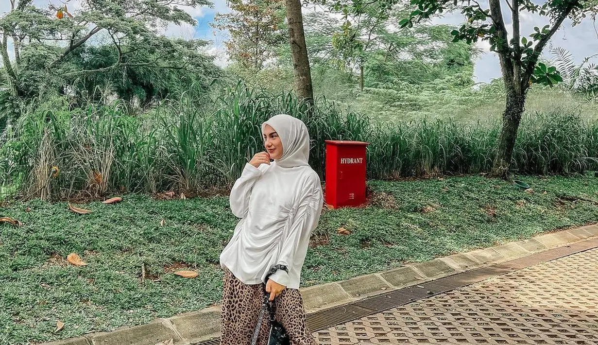 Untuk gaya kasual, kamu bisa tiru OOTD Irish Bella yang satu ini. Aktris yang baru saja melahirkan anak keduanya ini tampil memadukan blouse putih, hijab putih, dan rok macan tutul warna coklat.(Instagram/_irishbella_).