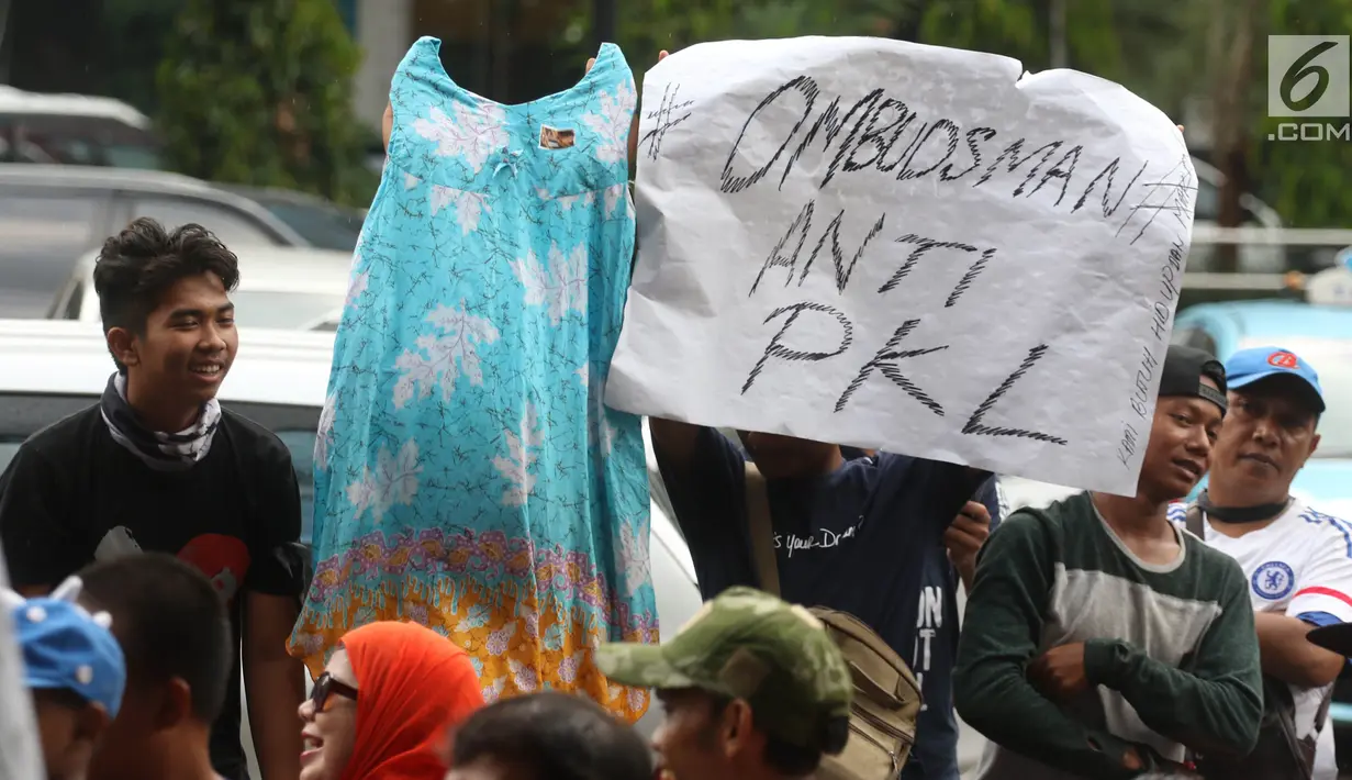 Pedagang kaki lima (PKL) Tanah Abang membawa poster dan dagangan mereka dalam unjuk rasa di depan kantor Ombudsman, Jakarta, Selasa (3/4). Aksi ini untuk mempertanyakan laporan Ombudsman mengenai penataan Tanah Abang. (Liputan6.com/Arya Manggala)