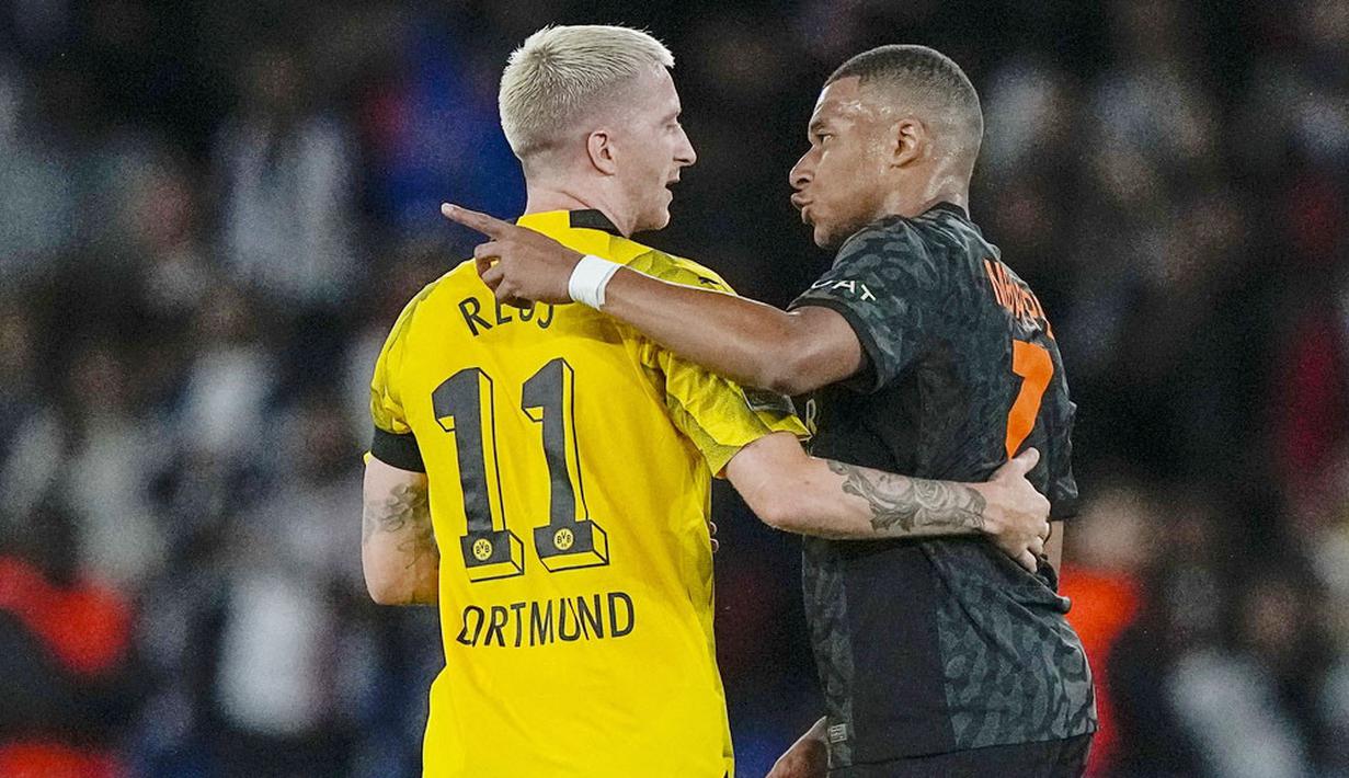 Pemain Paris Saint-Germain (PSG), Kylian Mbappe, berbincang dengan pemain Borussia Dortmund, Marco Reus, pada laga Liga Champions di Stadion Parc des Princes, Rabu (20/9/2023). PSG menang dengan skor 2-0. (AP Photo/Michel Euler)
