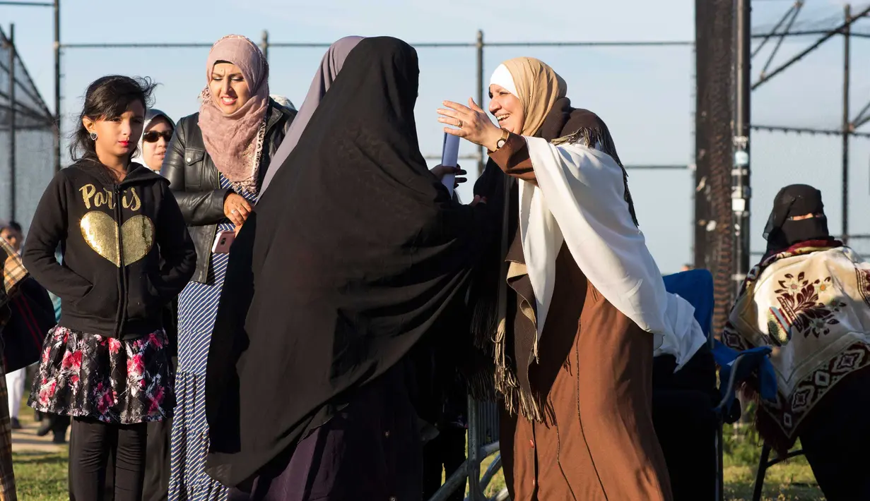 Wanita muslim saling berpelukan saat mereka bersiap melaksanakan salat Idul Adha di Taman Bensonhurst di wilayah Brooklyn di New York (1/9). Umat Muslim di seluruh dunia merayakan Hari RayaIdul Adha. (AP Photo / Mark Lennihan)
