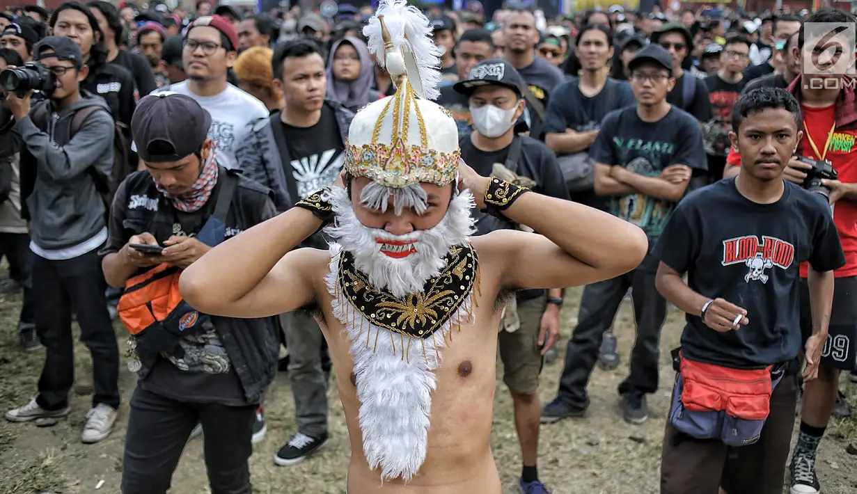 Aksi penonton berkostum hanoman saat menyaksikan Hammersonic Festival 2018 di Pantai Karnaval Ancol, Jakarta, Minggu (22/7). (Liputan6.com/Faizal Fanani)