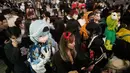 Orang-orang dengan kostum berjalan menyeberangi persimpangan jalan yang terkenal saat perayaan Halloween di distrik hiburan Shibuya, Tokyo, Jepang, 31 Oktober 2022. (AP Photo/Hiro Komae)