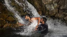 Dua pria bermain air di sungai saat musim panas di pinggiran Srinagar, Kashmir yang dikuasai India (4/7/2021). Musim panas waktu yang tepat untuk menghabiskan waktu di ruang terbuka hijau. Seperti warga Kashmir menikmati musim panas dengan pergi ke sungai. (AP Photo/Mukhtar Khan)