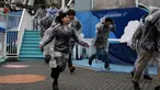 Sejumlah peserta memakai mantel plastik saat mengikuti simulasi evakuasi anti-rudal di taman hiburan Tokyo Dome City, Jepang, (22/1). Di tengah balistik Korea Utara, warga Jepang menggelar simulasi evakuasi anti-rudal. (AFP Photo/Toshifumi Kitamura)