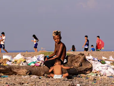 Anak-anak menyortir sampah di permukiman kumuh di sepanjang garis Pantai Baseco di Manila, Filipina (28/9/2019). Daerah memiliki pantai yang sering dikunjungi beberapa warga Manila meskipun tingkat coliform berbahaya di perairan yang berdekatan. (AFP Photo/Maria Tan)